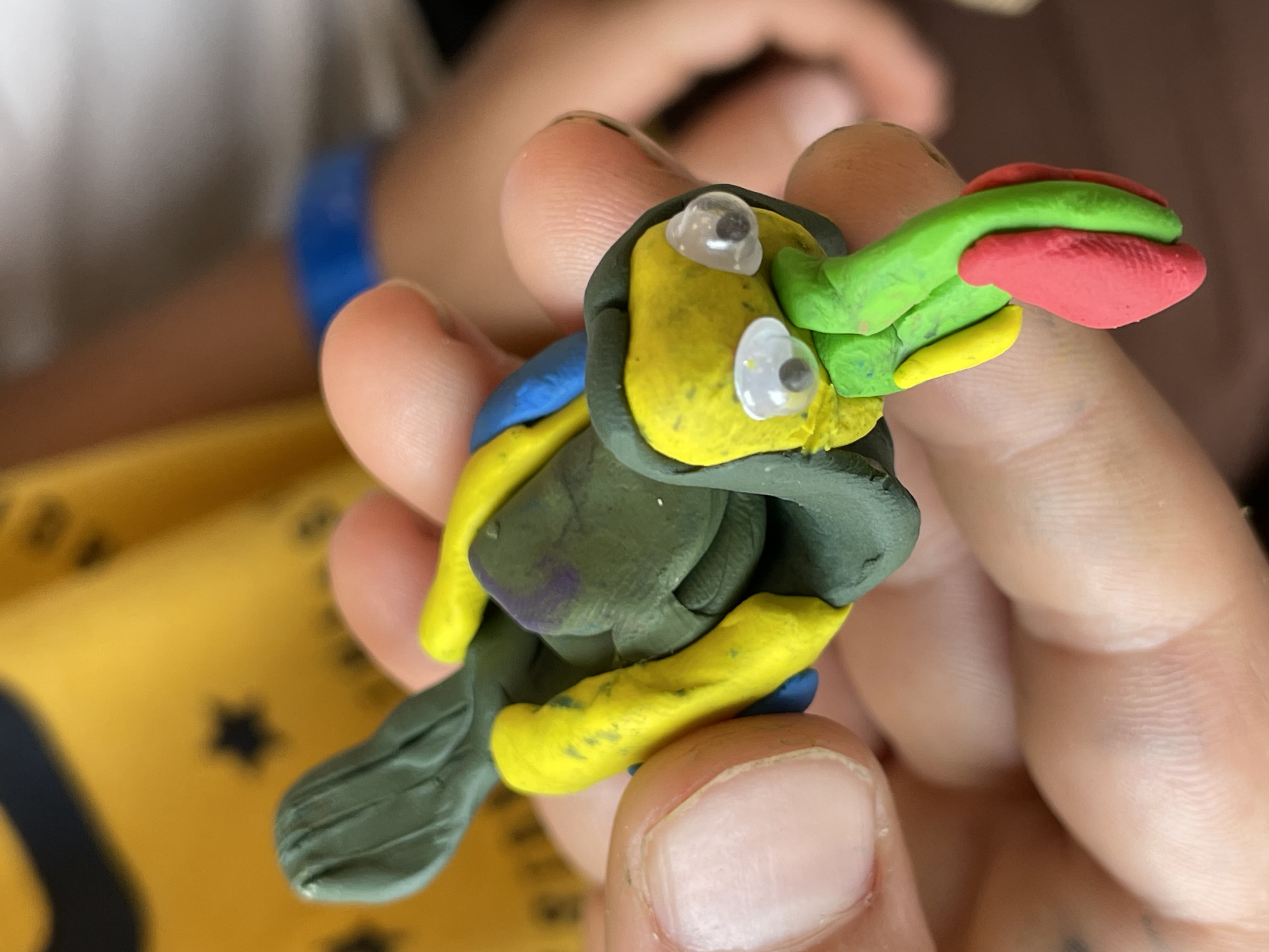 Child comparing their clay Toco Toucan to a real toucan on the cover of Ranger Rick magazine