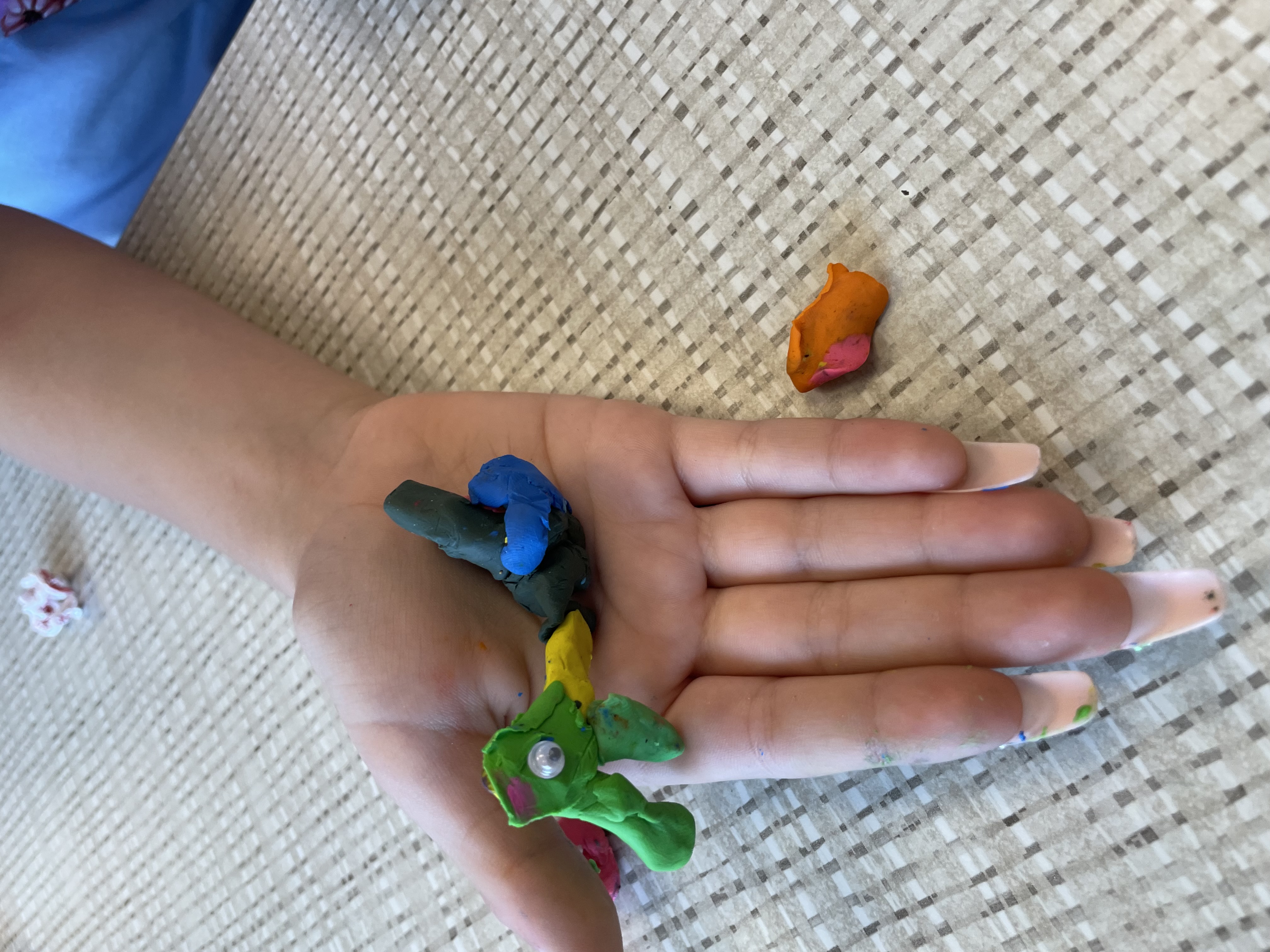 Child holding a detailed clay Toco Toucan with green and orange beak at Chick-fil-A