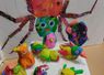 Children's craft display with colorful spider and clay creatures